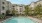 The pool area at our apartments in Dedham, featuring umbrellas, beach chairs, and a view of the apartments.