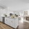 Model kitchen at our apartments for rent in Dedham, MA, featuring wood grain floor paneling and white cabinetry.