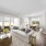 Furnished living room and dining room at The Avens at Dedham Station featuring a couch, coffee table, dining table set for six, and views of lush greenery