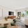 Furnished living room with a couch, tv on a brown entertainment stand, dining table for four, coffee table, and sliding door leading out to a private patio.